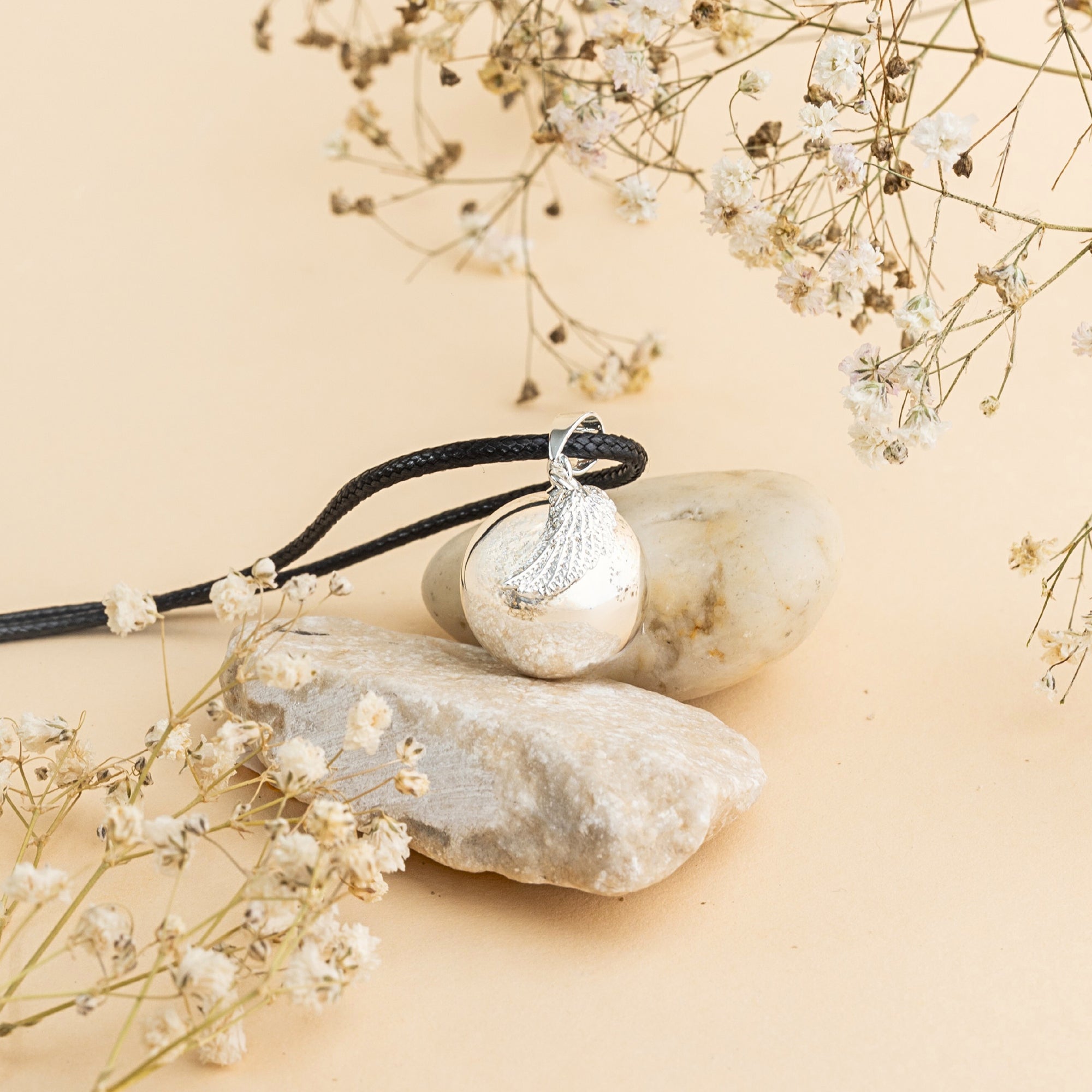 Stříbrná rolnička s motivem andělského křídla – detail povrchu