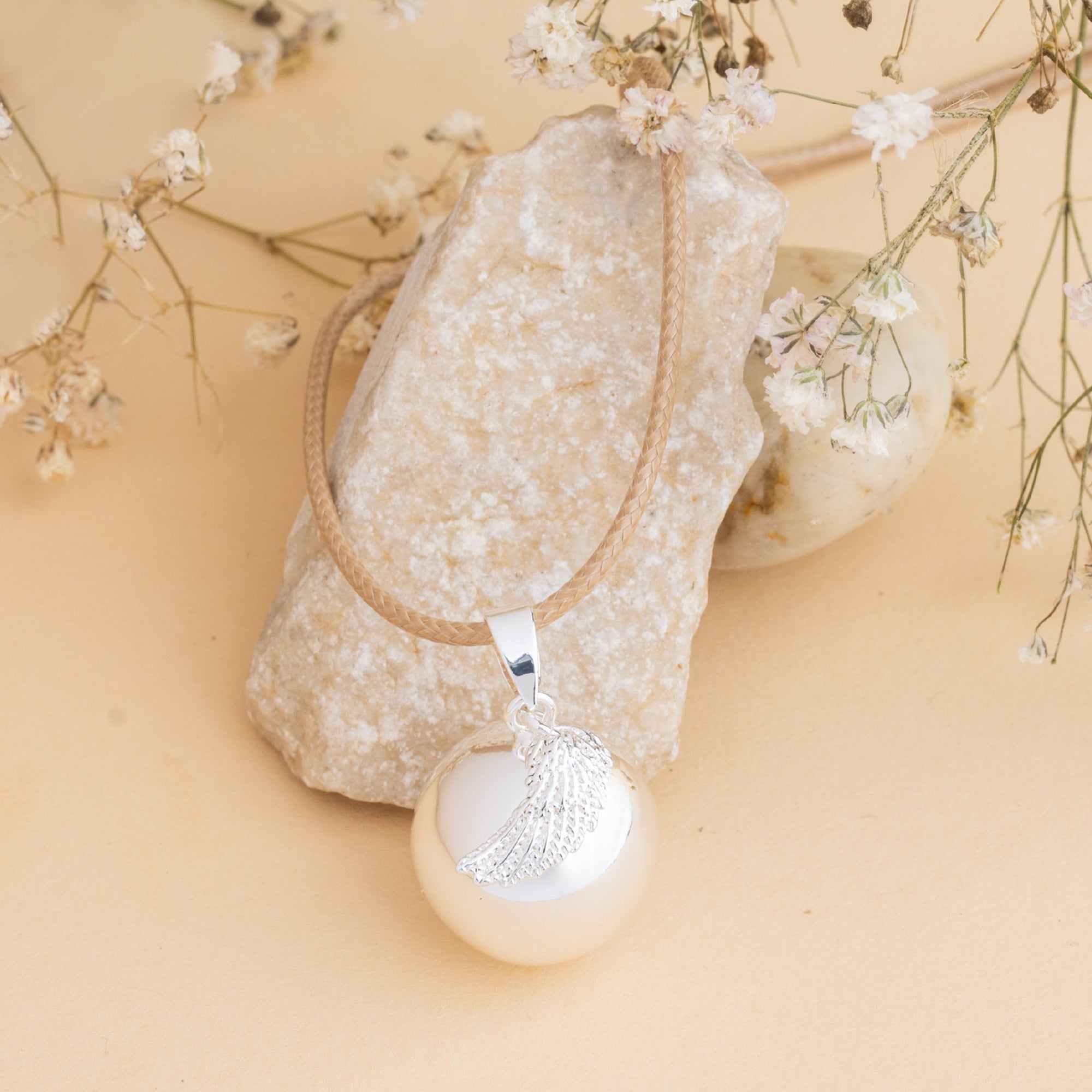 Stříbrná rolnička s motivem andělského křídla – detail povrchu